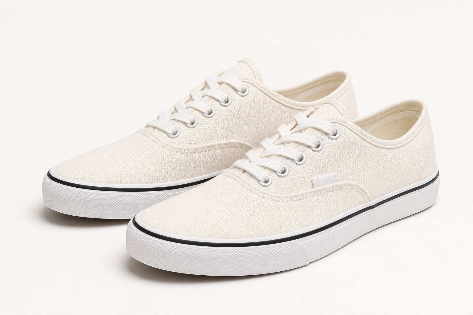 White low-top canvas sneakers with white laces and rubber soles