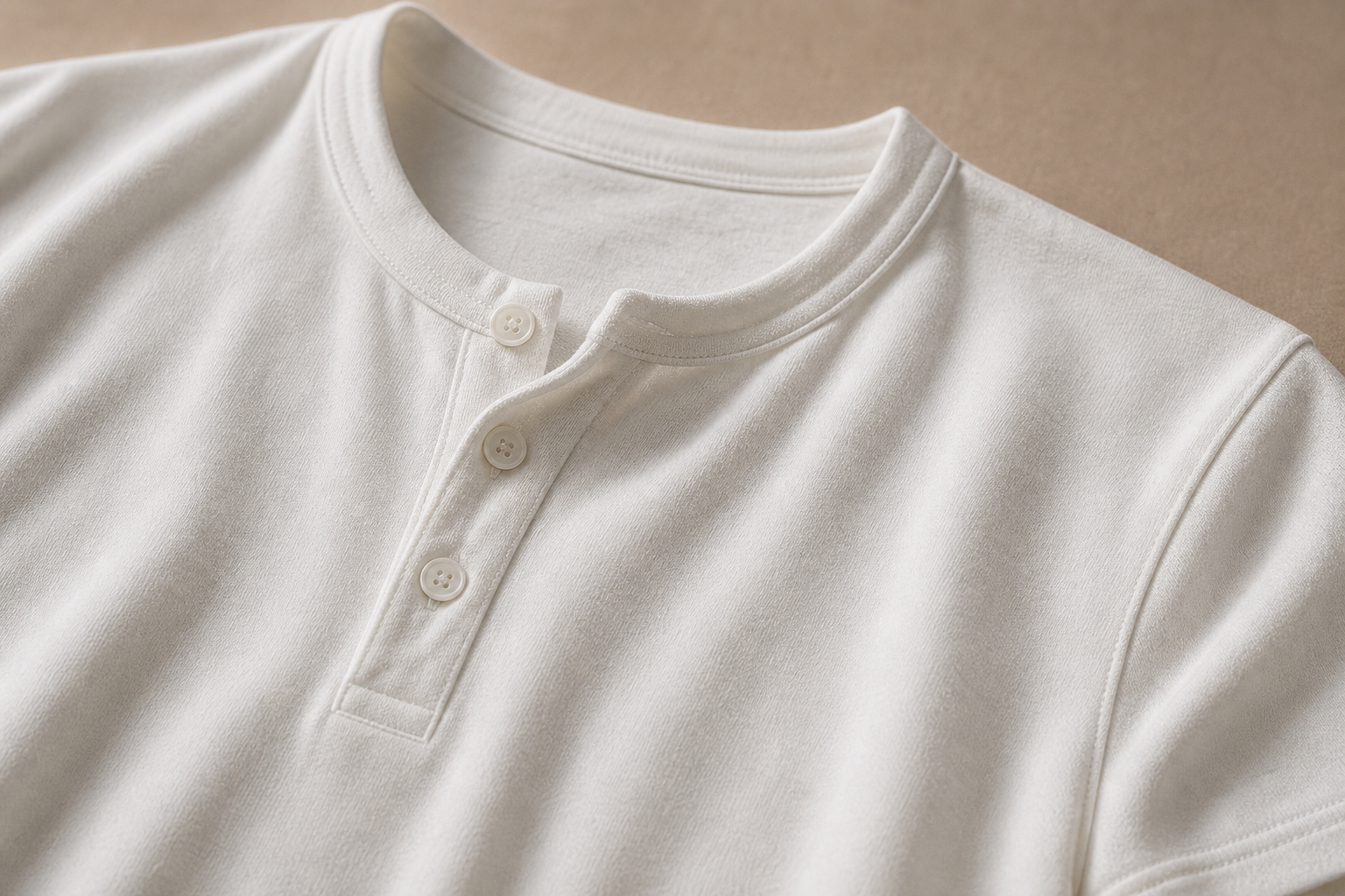 Close-up of the white henley fabric, neckline, stitching, and 3-button placket
